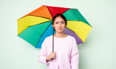 Poster - young pretty woman feeling sad and whiney with an unhappy look and crying. umbrella concept