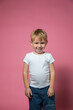 © галина шарапова - Caucasian boy 3 years old makes faces while looking at camera on pink background