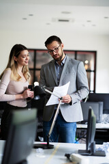 Wall Mural - Colleagues in office. Businesswoman and businessman discussing work in office.