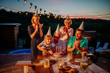 Happy caucasian family celebrating birthday with cake