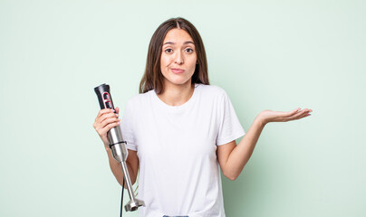 Poster - young pretty woman feeling puzzled and confused and doubting. hand mixer concept