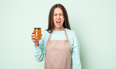 Poster - young pretty woman shouting aggressively, looking very angry. peach jelly concept