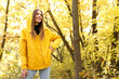 © BartLoveyou - a woman smiles in a yellow autumn jacket in front of the yellow autumn leaves in October. free space for text