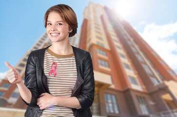 Wall Mural - A woman in T-shirt with a pink satin ribbon symbolizing International Breast Cancer Day,