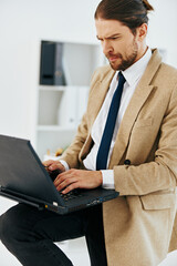 fashionable man holding a phone laptop office lifestyle