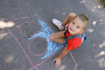 Canvas Print - Cute little child drawing with colorful chalk on asphalt