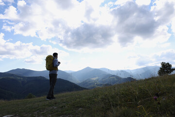 Sticker - Tourist with backpack enjoying mountain landscape, space for text