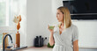 © artshake - Young woman drinks green smoothie in nice kitchen