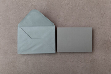 Wall Mural - Blank grey card with grey paper envelope template mock up on a concrete background