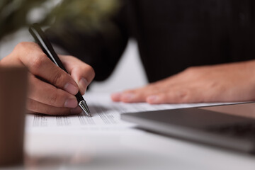 Poster - A man signs a contract. Close up. Business deal concept meeting. A man signs a contract. A male hand with a pen makes notes in the office.