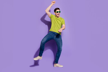 Canvas Print - Photo of pretty handsome young man wear green t-shirt dark glasses dancing riding horse smiling isolated violet color background