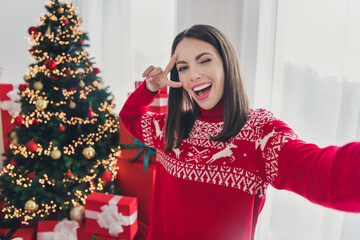 Poster - Photo of young cheerful girl blogger take selfie fooling show peace v-symbol decor christmas tree indoors