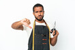 © luismolinero - Young Ecuadorian design man holding scissors isolated on white background showing thumb down with negative expression