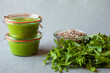 Fresh homemade arugula and sunflower seeds green pesto dip in glass jars. Vegan diet.