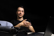 © Iurii Gagarin - man midway between a typewriter and laptop on black background in low key.The concept of the past and the future.