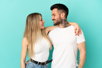 Wall Mural - Young couple over isolated blue background happy and laughing