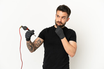 Wall Mural - Tattoo artist man over isolated white background having doubts and thinking