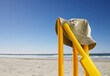 © SuperStock - Sunhat and bat resting on yellow cricket stumps at the beach