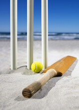 Bat And Ball Laying Beside Cricket Stumps On The Sand At The Beach