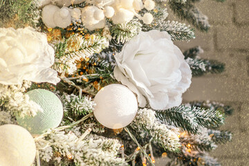 Close up of balls on christmas tree. New Year concept. White roses in d cor of Christmas tree. background with Christmas decorations. Copy space