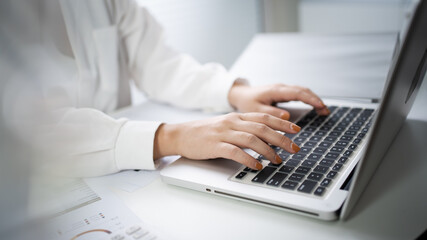 Woman working by using a laptop computer Hands typing on keyboard. writing a blog. Working at home are in hand finger typewriter