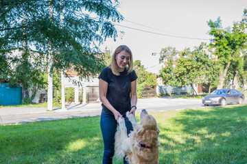 Wall Mural - young woman with her retriever in the park.