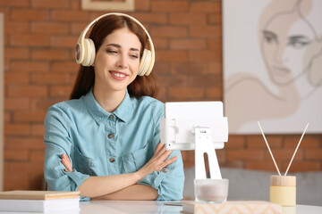 Wall Mural - Young woman with tablet computer listening to audiobook at home