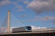 Skytrain passing Cable stayed bridge in cloudy and blue sky in Vancouver