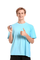 Wall Mural - Sporty young man with pulse oximeter showing thumb-up on white background