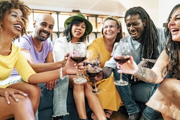 Group of friends having fun at pre dinner party aperitif buffet drinking cocktails and eating snacks - Young people spending time together at home - Bright vivid filter with natural interior lighting