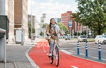 Traffic, City Transport And People Concept - Happy Smiling Woman Riding Bicycle Along Red Bike Lane Or Two Way Road On Street