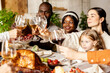 Happy family celebrate Thanksgiving day, sitting at table with roasted turkey and holiday traditional food, dishes. Drinking wine