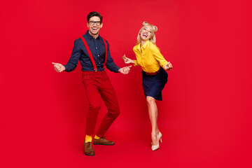 Photo of funky handsome young guy lady wear pin up clothes smiling dancing swing beating fingers rhythm isolated red color background