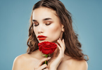 Wall Mural - attractive woman and red lips rose flower close-up blue background