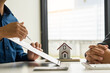© ArLawKa - Sales representatives and new homeowners sign a home purchase or rental contract on the table. Real estate concepts or bank officers explain loan interest to customers with home or office loan contrac