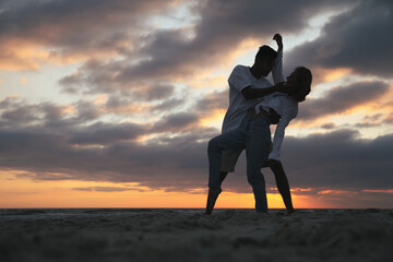 Poster - Happy couple dancing on beach at sunset