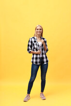 Full Length Laughing Model In Studio. Looking At Camera. Isolated Yellow Background