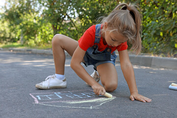 Canvas Print - Cute little child drawing house with colorful chalk on asphalt