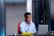 © Wavebreak Media - Smiling african american male computer technician using laptop working in business server room