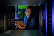 © Wavebreak Media - Happy african american female computer technician using tablet and working in server room