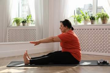 Poster - Overweight mature woman stretching on floor at home