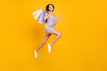 Sticker - Full length body size woman smiling jumping running on sale with bags laughing isolated vivid yellow color background