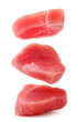 Raw tuna medallions falling on a white background. Isolated
