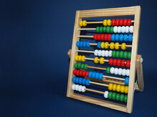 Wooden Children's Abacus Stand On A Dark Blue Background, Side View. Preschool Education For Children