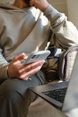 Wall Mural - man holds a phone in his hands and plays and he is happy with the result. a young man sits on the co