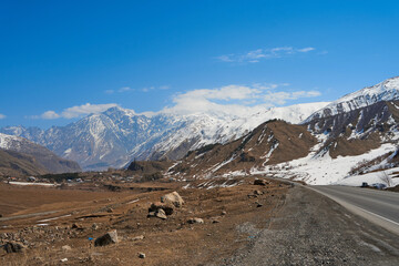 Wall Mural - In a mountain valley, a breathtaking landscape of giant covered mountains in the background