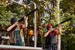 © Roman - Young caucasian skilled people in goggles and headset on tactical gun training classes, aiming rifle at target. Shooting and Weapons. Outdoor Shooting Range At Summer Evening. focus on female