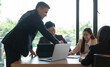 © Natee Meepian - Group of business people busy discussing financial matter during meeting. Corporate Organization Meeting Concept.