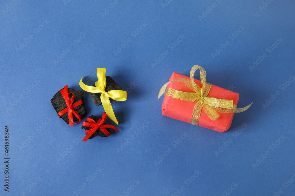 Coal with Christmas gift on color background
