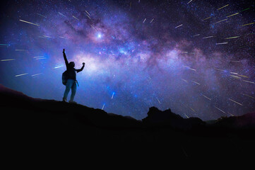 Wall Mural - Landscape with Milky Way. Night sky with stars and silhouette of a standing happy man on the mountain, Success or winner, leader concept. High iso with Noise.